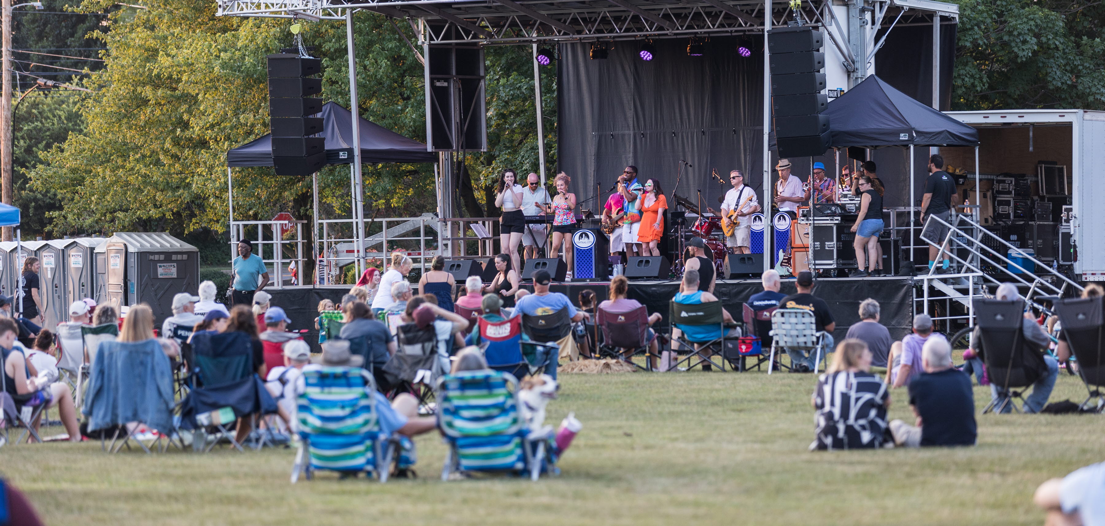 People facing towards and outdoor stage ready for music concert in the park 